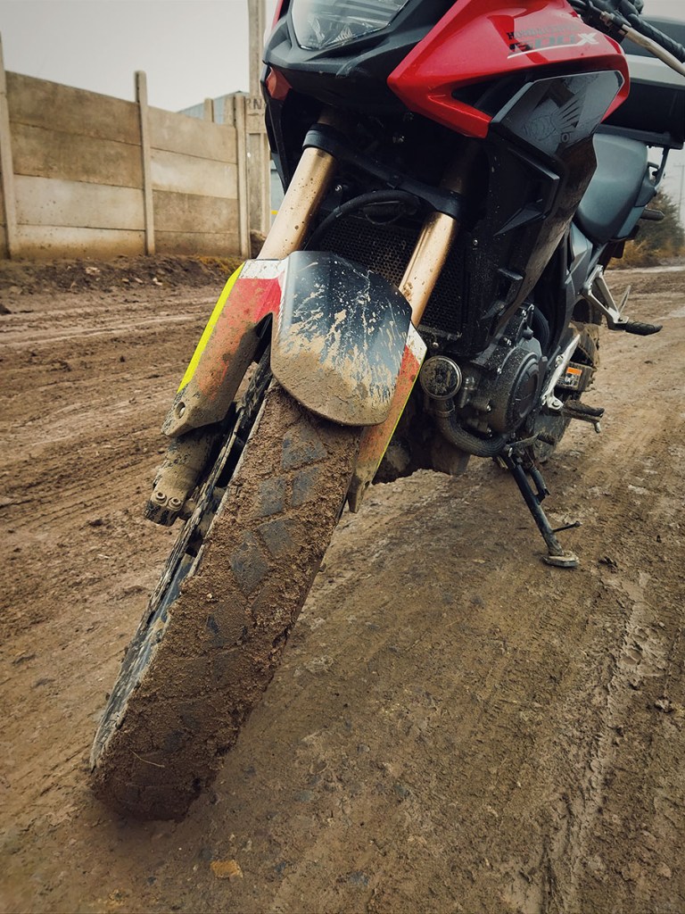 Mi Honda CB500X con sus neumáticos de fábrica completamente embarrados.
